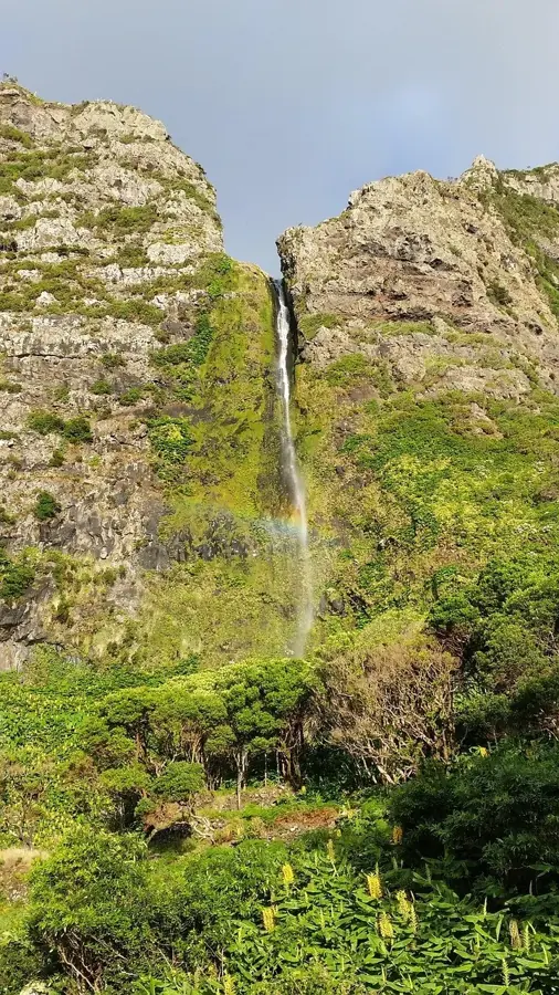 Una cascata sottile lungo la parete di roccia a Flores