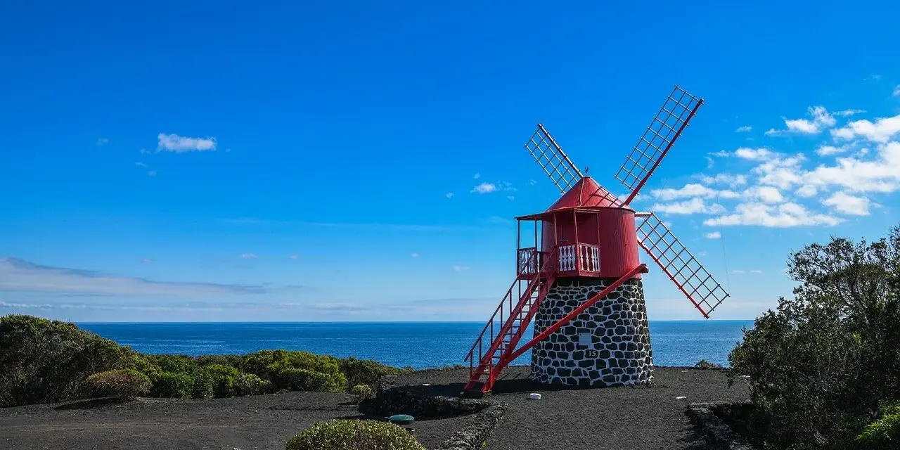 Un mulino a vento tradizionale con la cupola rossa sulla costa delle Azzorre