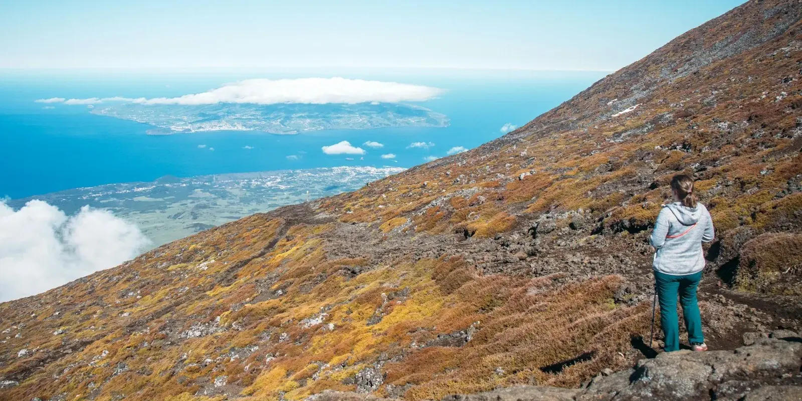 Un escursionista sul pendio del vulcano Pico sopra l'oceano