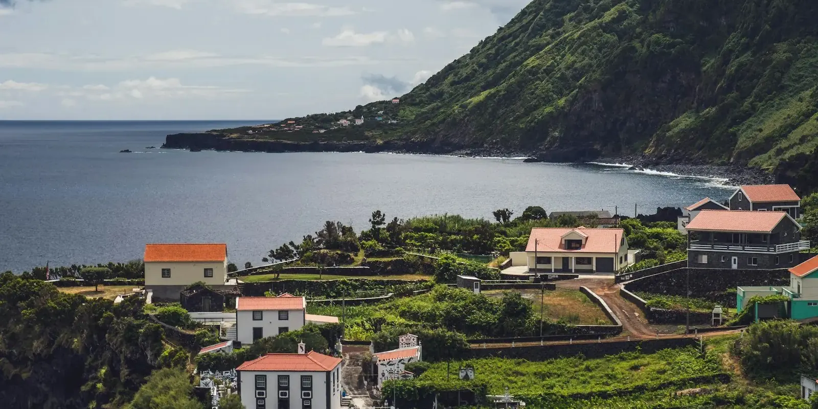 Le case di una fajã ai piedi delle scogliere verdi di São Jorge