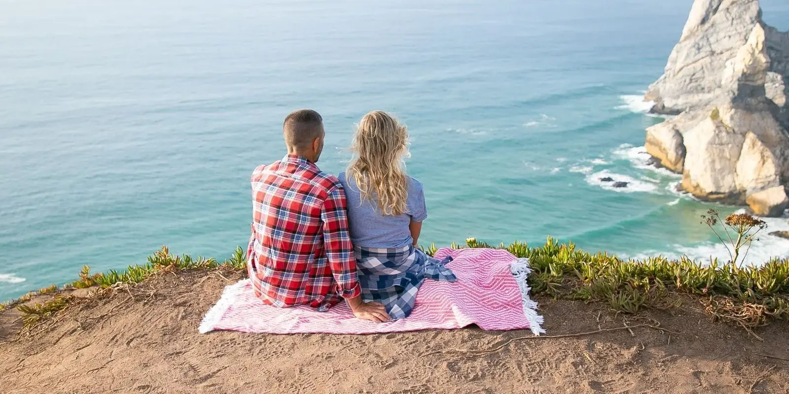 Una coppia in picnic su una scogliera sopra l'oceano