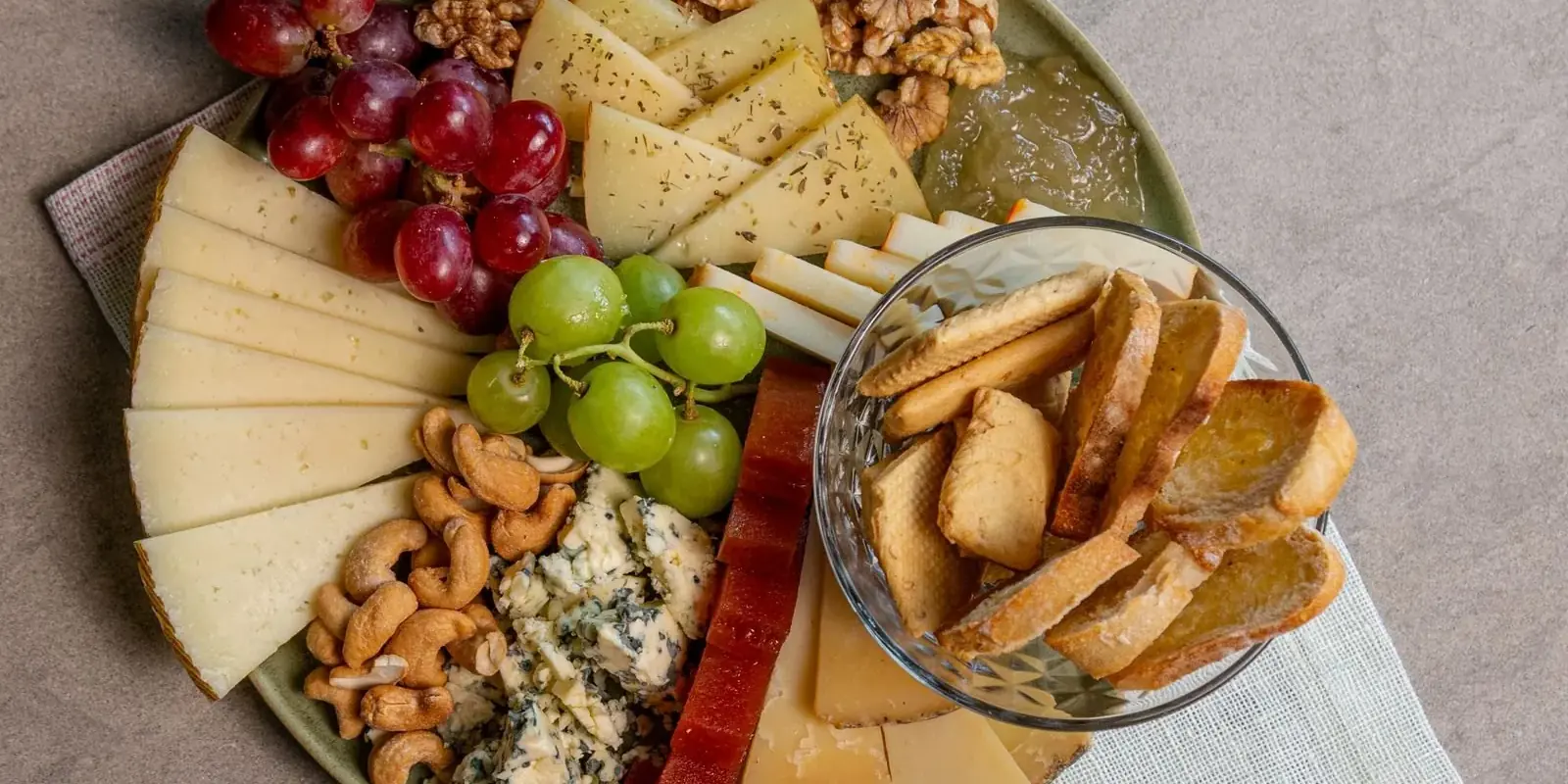 Tagliere di formaggi, frutta secca e uva per la degustazione