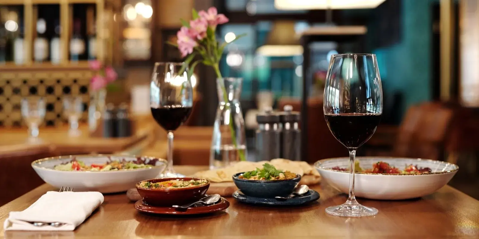 Calici di vino rosso e piccoli piatti su un tavolo di locale